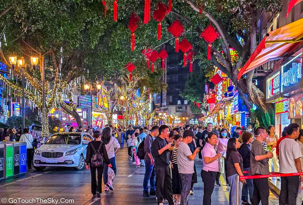 แสงไฟและป้ายร้านค้าสีสันสดใสบนถนนปายิ